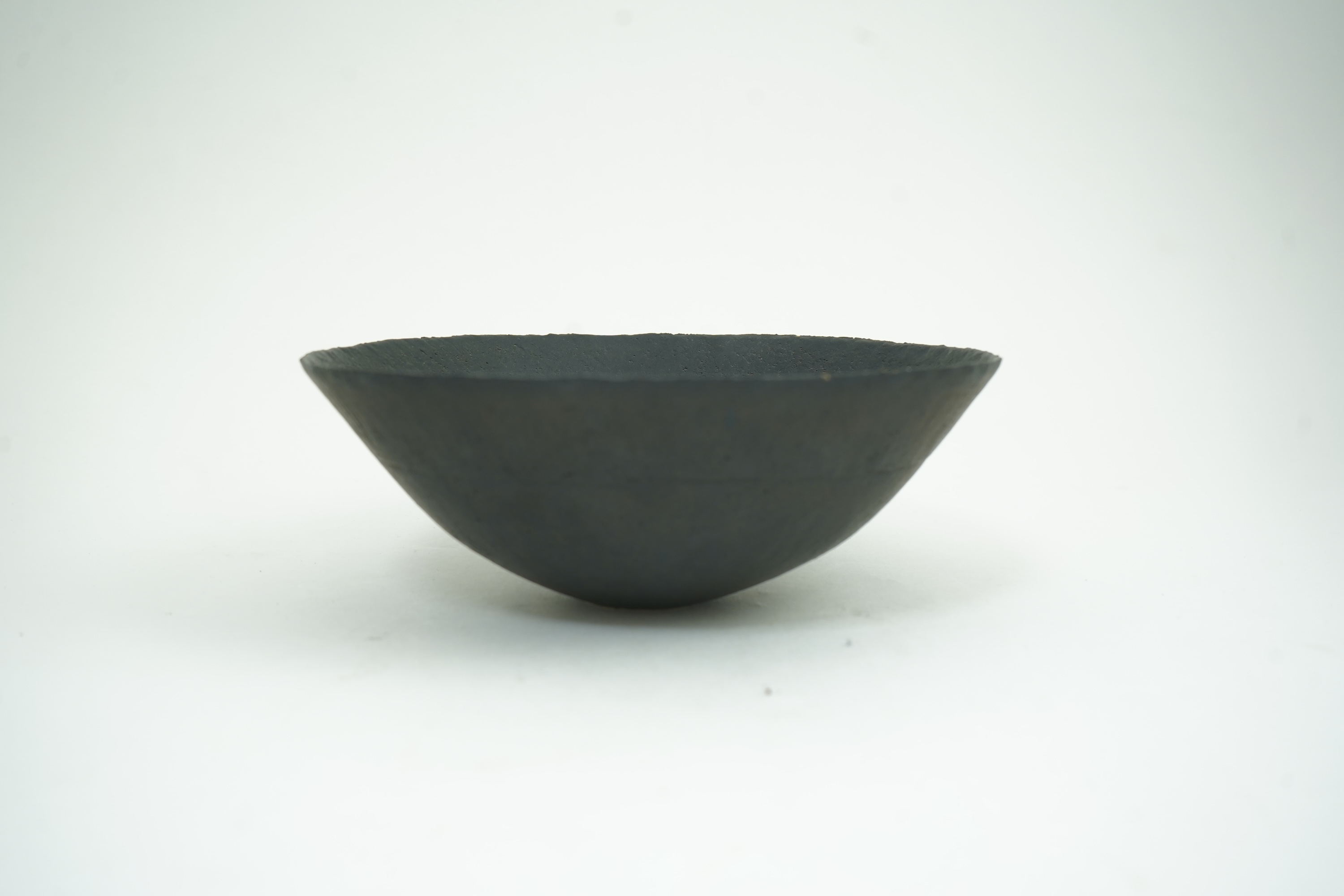 John Ward (1938-2023): A hand-built stoneware black glazed bowl with irregular rim